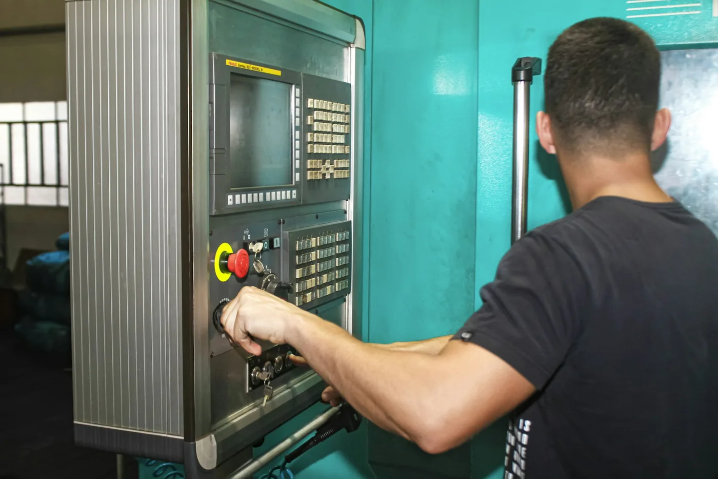 Zerspanungsmechaniker an der Steuerung einer CNC-Maschine